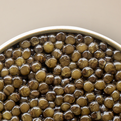 a close up of a bowl of caviar pearls with a white background