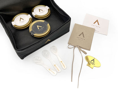 three jars of astrea caviar are in a black bag with serving spoons