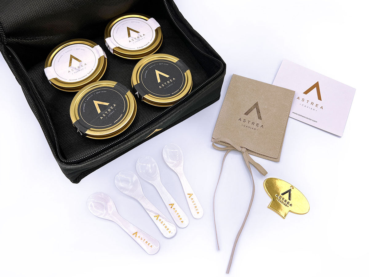 four jars of astrea caviar are in a black bag next to four serving spoons
