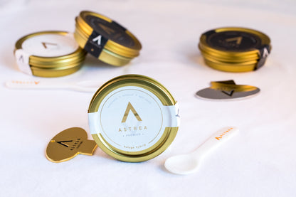 a tin of astrea kaluga hybrid caviar with a tin opener and serving spoon