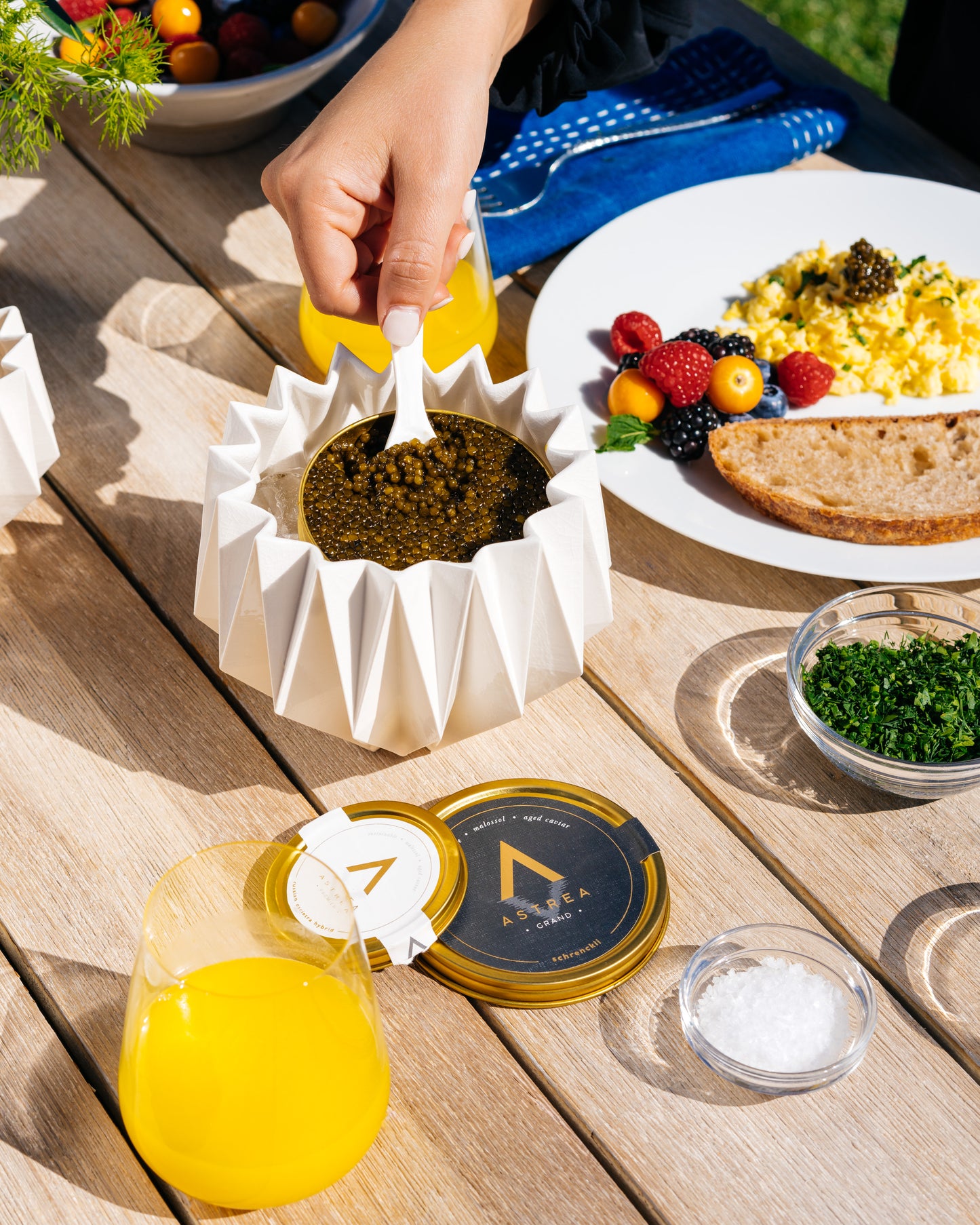 a person is dipping a spoon into a jar of astrea caviar